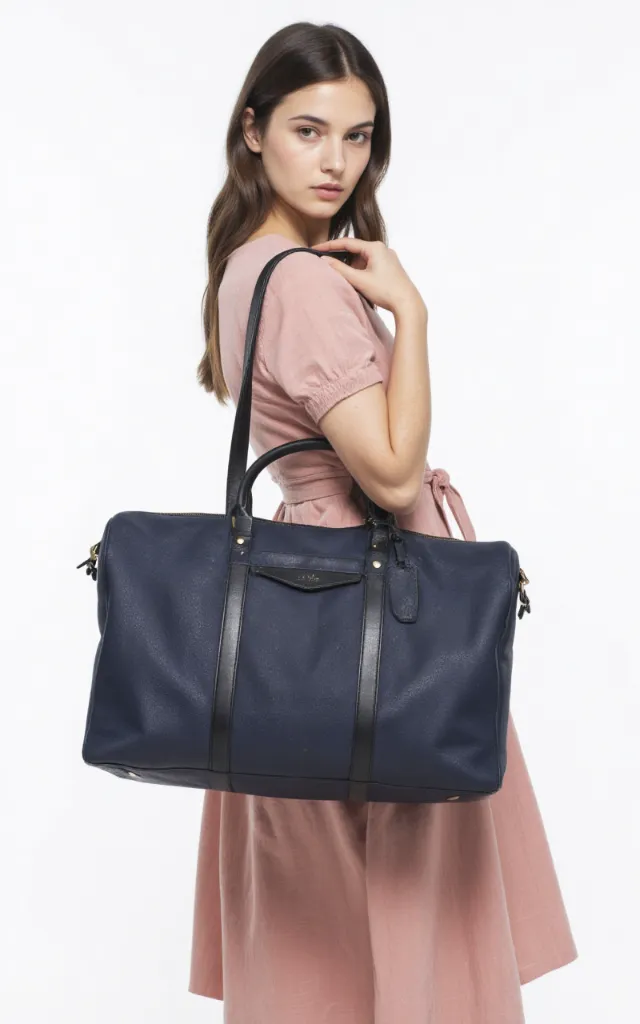 A French female model with a Travel bag, wearing a dress, against a white background, in a front   facing close   up